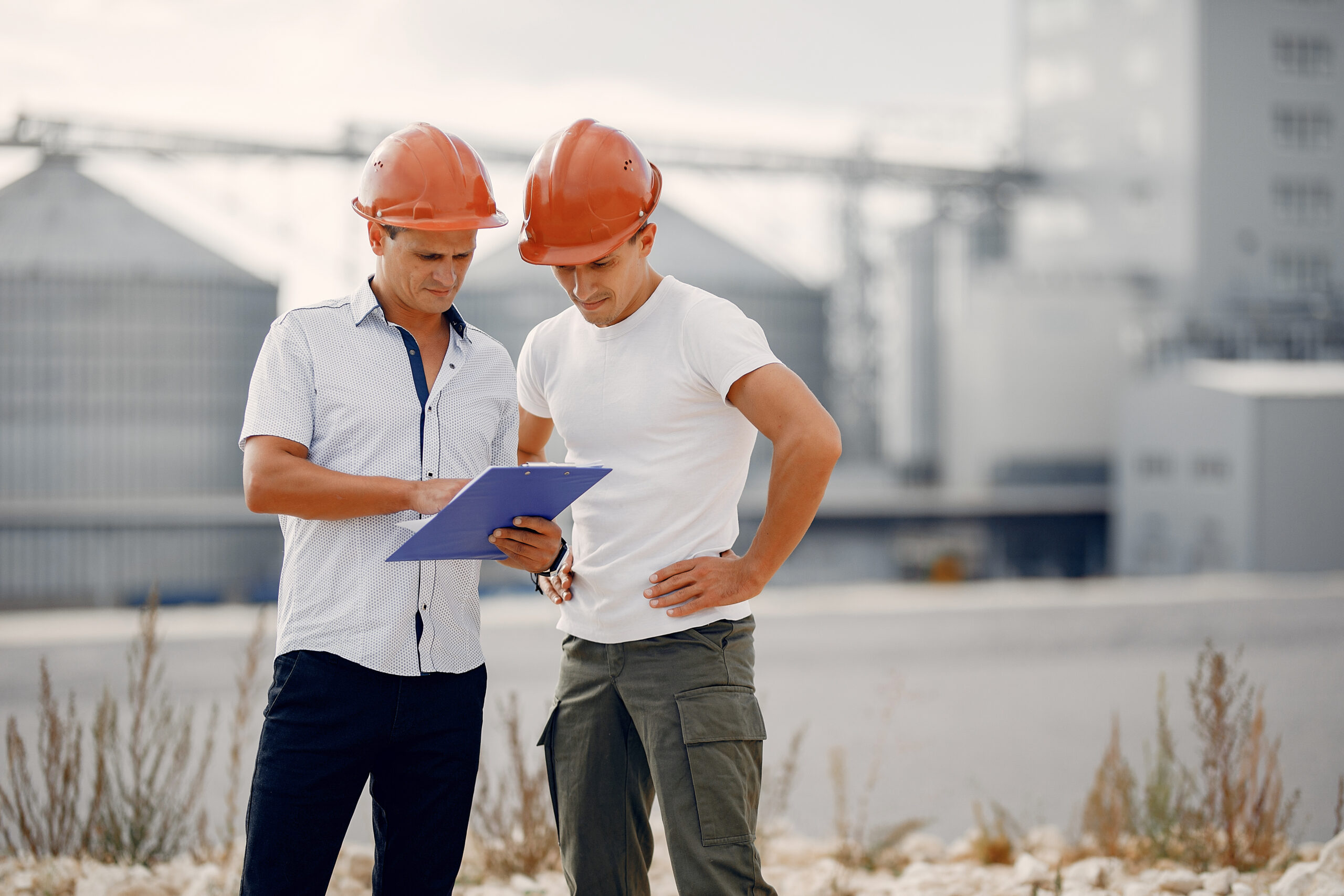 Еngineers in a halmet standing by the factory